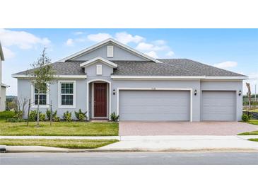 Charming single-story home featuring a three-car garage and well-manicured lawn at 7193 Dilly Lake Ave, Groveland, FL 34736