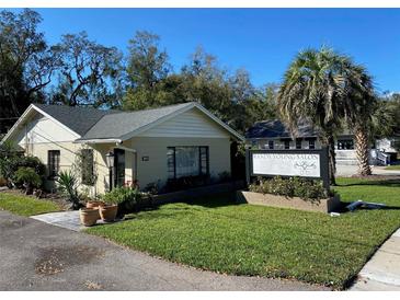 Charming one story commercial building featuring well maintained lawn, palm tree and elegant signage at 911 N Donnelly St, Mount Dora, FL 32757