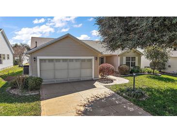 Charming single Gathering home with a two car garage, well manicured lawn, and mature trees at 9243 Se 171St Cooper Loop, The Villages, FL 32162