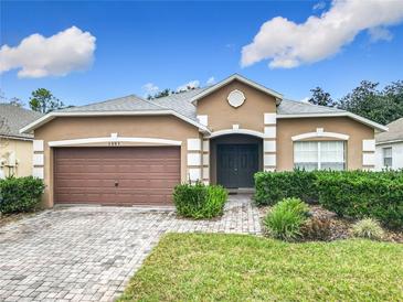 Charming single Gathering home featuring a well manicured lawn, beautiful brick driveway and two car garage at 1007 Balmoral Dr, Davenport, FL 33896