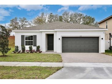 Charming single-story home featuring a two-car garage and well-manicured lawn at 1197 Stratton Ave, Groveland, FL 34736