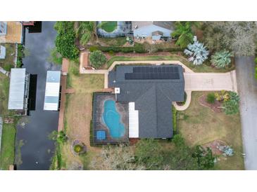 Stunning aerial view of home featuring a private pool, dock, and solar panels at 12338 S Putney Ct, Leesburg, FL 34788