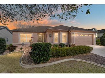 Charming home featuring a well manicured front yard, beautiful landscaping, and a two-car garage at 1537 Eastover Ter, The Villages, FL 32162