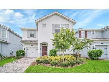 Charming two-story home with a well-manicured lawn and colorful landscaping at 1614 Moon Valley Dr, Davenport, FL 33896