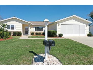 Charming single-story home boasts a well-manicured lawn and inviting curb appeal with lush green grass and mature shrubs at 17937 Se 107Th Ter, Summerfield, FL 34491