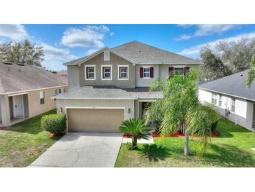 Inviting two-story home featuring a well-manicured lawn and a two-car garage at 201 Andover Dr, Davenport, FL 33897