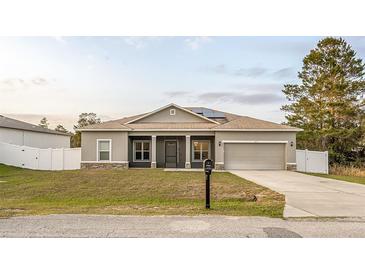 Charming single-story home featuring a two-car garage, well-maintained lawn, and neutral exterior paint at 215 Elm Ct, Kissimmee, FL 34759