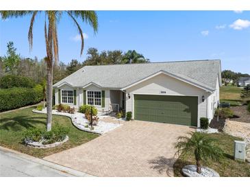 Charming single-story home with a brick driveway, well-manicured lawn, and an attached two-car garage at 25274 Lost Oak Cir, Leesburg, FL 34748