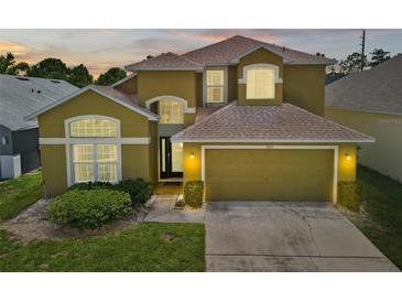 Charming two-story home featuring a two-car garage, manicured lawn, and well-maintained landscaping at 2903 Blooming Alamanda Loop, Kissimmee, FL 34747