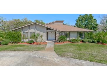 Charming single-story home with a stone accent entry, mature trees, and well-manicured lawn at 2918 Cocovia Way, Leesburg, FL 34748