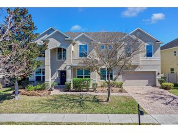 Stunning two-story home with mature trees, brick driveway, and lush landscaping at 4951 Cypress Hammock Dr, St Cloud, FL 34771