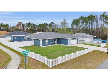 Charming single-story home featuring a well-manicured lawn and white picket fence at 54 Pecan Pass, Ocala, FL 34472