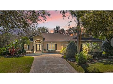 Charming single-story home featuring a brick driveway and manicured landscaping at 6240 Tremayne Dr, Mount Dora, FL 32757