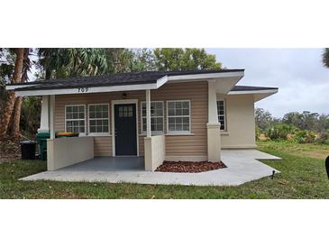 Charming single-story home with a covered front porch, manicured lawn, and craftsman style at 709 S Highland St, Mount Dora, FL 32757