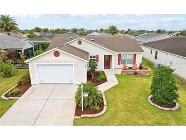 Well maintained single-story home with a two car garage and meticulously manicured lawn at 853 Abaco Path, The Villages, FL 32163