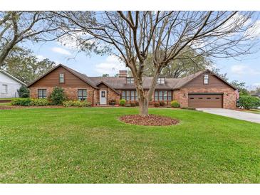 Charming brick home with a well-maintained lawn and mature trees at 9906 County Road 114A, Wildwood, FL 34785