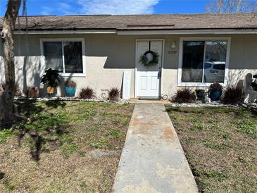 Charming single-story home with a welcoming front door, tidy landscaping, and sidewalk to the entrance at 12237 Tavares Ridge Cir # 67, Tavares, FL 32778