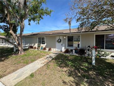 Charming single-story home featuring a well-maintained lawn, welcoming front door, and ample natural light through large windows at 12237 Tavares Ridge Cir # 67, Tavares, FL 32778