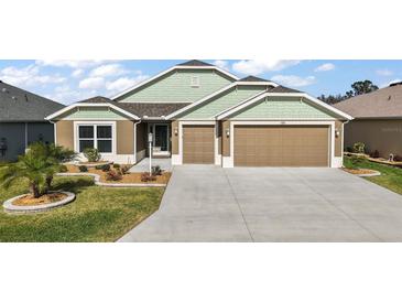 Charming single-Gathering home featuring a well-maintained lawn and a two-car garage at 1581 Rowell St, The Villages, FL 34762
