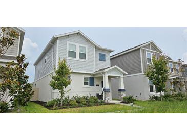 Charming two-story home featuring gray shingles and a well-manicured front yard at 1723 Happiness Row, Kissimmee, FL 34744