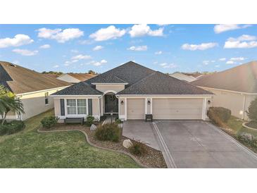 Inviting single Gathering home with a well-maintained lawn and attached two car garage at 2212 Bachman Path, The Villages, FL 32162