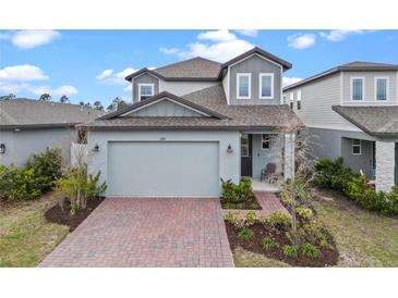 Beautiful two-story home showcasing a brick driveway and modern architectural details at 2289 Mystic Maze Ln, Minneola, FL 34715