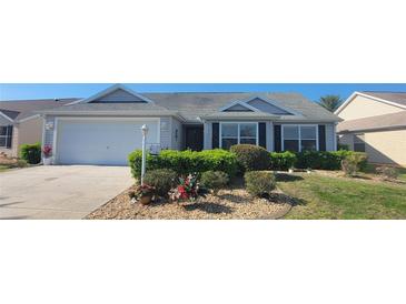 Charming single-story home with well-maintained landscaping and an attached two-car garage at 2304 Jonesbury Run, The Villages, FL 32162
