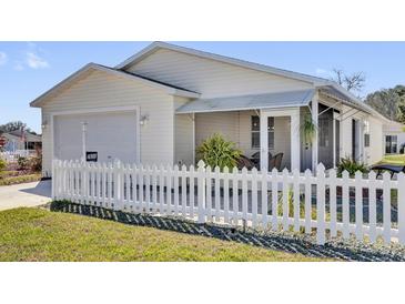 Charming single-story home with a well-manicured lawn and white picket fence at 2606 Olivarez Way, The Villages, FL 32162