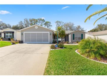 Charming single-story home features a manicured lawn, two-car garage, and welcoming curb appeal at 2738 Privada Dr, The Villages, FL 32162