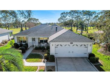 Charming single-story home with a well-manicured lawn and attached two car garage at 720 Camino Del Rey Dr, The Villages, FL 32159