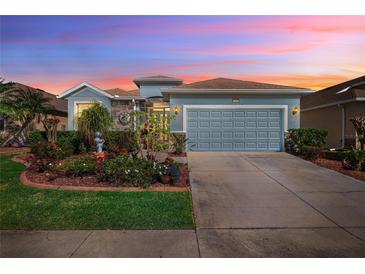 Charming single Gathering home featuring beautiful landscaping, stone accents and a two car garage at 8780 Bridgeport Bay Cir, Mount Dora, FL 32757