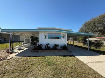 Charming single-story home featuring a covered porch, carport, and manicured front yard at 1127 Belmont Cir, Tavares, FL 32778