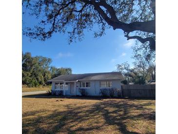 Cozy single-story home with light blue exterior paint and well-maintained front yard beneath a blue sky at 115 N Galena Ave, Minneola, FL 34715