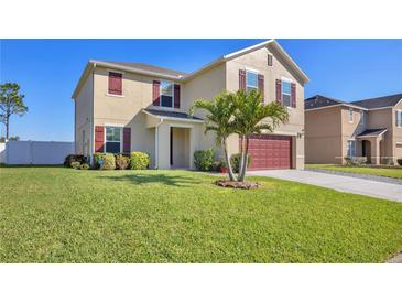 Two-story home features manicured lawn, mature landscaping, and a two car garage at 16707 Broadford Ln, Clermont, FL 34714