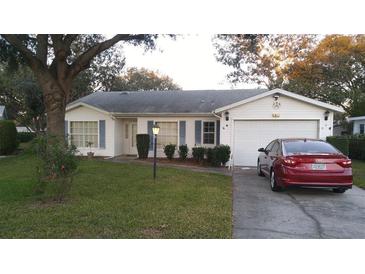 Charming single-story home with well-maintained lawn, neat shrubs, and attached garage at 25212 Clifford Hl, Leesburg, FL 34748