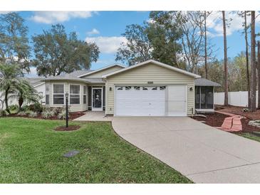 Charming single-story home featuring well-maintained landscaping, light siding, and a two-car garage at 32222 Summertree Circle, Leesburg, FL 34748