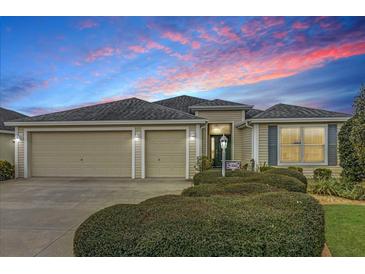 Charming single-story home featuring a well-maintained front yard, two-car garage, and inviting entrance at 3262 Dalkeith Ter, The Villages, FL 32163