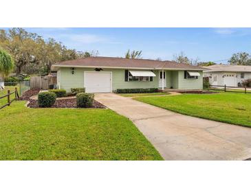 Charming one-story home featuring a well-maintained lawn, awning-covered windows and attached garage at 330 N Sunset Dr, Mount Dora, FL 32757