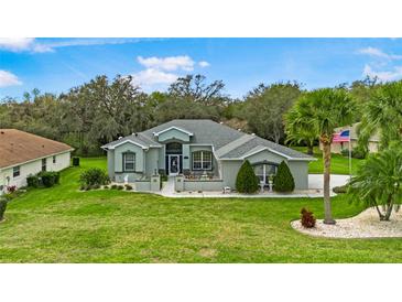 Charming single-story home with a well-manicured lawn, mature trees, and inviting curb appeal at 5121 Aurora Dr, Leesburg, FL 34748