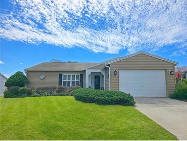 Charming single story home with a well-maintained lawn, lush landscaping, and two car garage at 6106 Kittiwake Dr, Lakeland, FL 33809