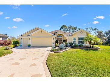 Charming single-story home featuring a well-manicured lawn, beautiful landscaping, and a spacious three-car garage at 7885 Se 166Th Hibernia Ln, The Villages, FL 32162