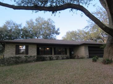Charming single-story brick home featuring a well-manicured front lawn and attached garage at 1009 Linda Glen Ave, Fruitland Park, FL 34731