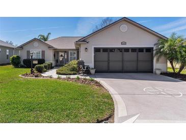 Charming single-story home with lush lawn, neat landscaping, and a two-car garage at 12199 Se 175Th Loop, Summerfield, FL 34491