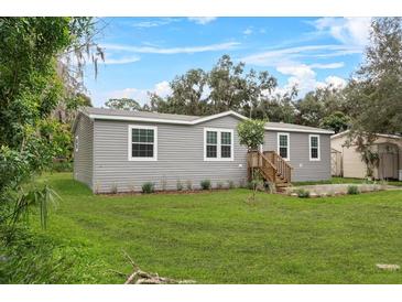 Charming single-story home boasts a well-manicured lawn and classic gray siding at 147 Woodstork Way, Frostproof, FL 33843