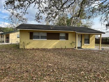 Charming single-story yellow home with a dark roof, cozy front porch, and easy access at 1508 Jefferson Dr, Mount Dora, FL 32757