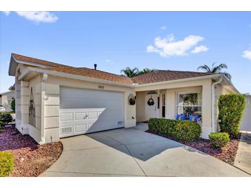 Charming single story home with a well manicured lawn, a garage, and a welcoming front entrance at 1923 Greeleyville Ter, The Villages, FL 32162