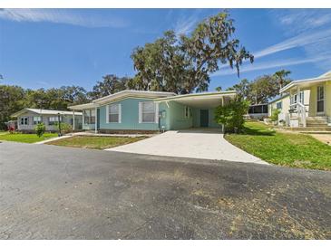 Charming single-story home featuring a carport, freshly painted exterior, and a well-maintained front yard at 2 Heather Ln, Fruitland Park, FL 34731