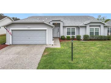Charming single-story home featuring a well-maintained lawn, inviting entryway, and attached garage at 25110 Meriweather Rd, Leesburg, FL 34748