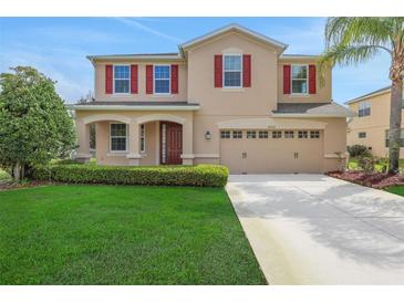 Charming two-story home with a well-manicured lawn, attached garage, and decorative red shutters at 30342 Gidran Ter, Mount Dora, FL 32757