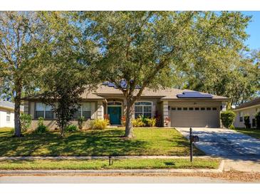 Charming single-story home with well-maintained lawn, mature tree, solar panels and attached two car garage at 519 Hearthglen Blvd, Winter Garden, FL 34787